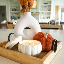 Load image into Gallery viewer, A styled autumn tabletop scene with a white ceramic vase holding dried orange foliage, a white candle in a ribbed pumpkin-shaped holder, a textured orange decorative pumpkin, and a wooden tray in a bright kitchen setting.