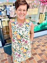 Load image into Gallery viewer, Woman wearing a floral dress standing in front of a store entrance.