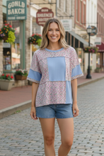 Load image into Gallery viewer, Woman wearing a floral and blue patchwork top. 
